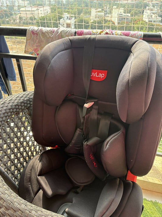 Children's car seat with UV Lap logo on a balcony