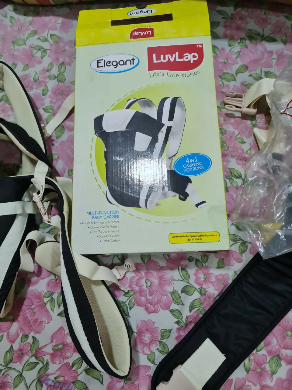 Elegant Luvlap baby carrier with packaging on a floral surface