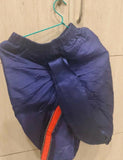 Blue jacket with a red zipper on a hanger against a tiled wall.