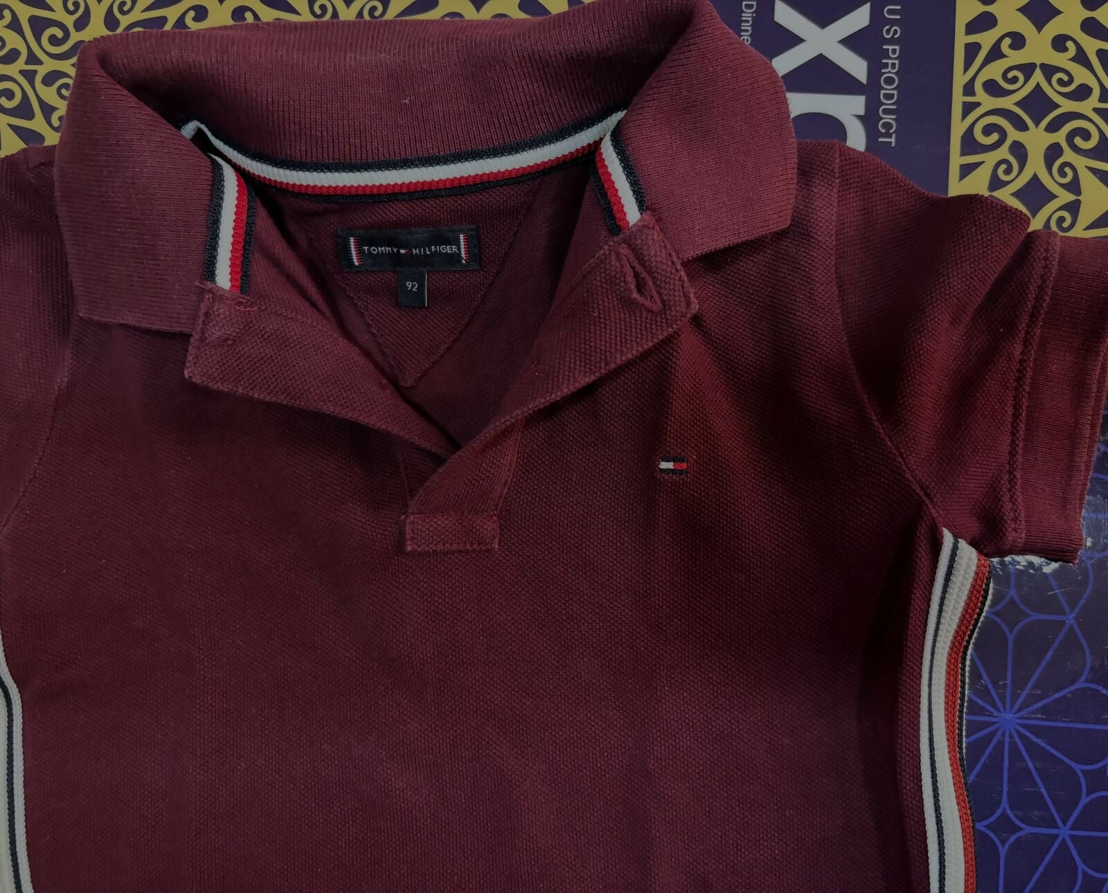 TOMMY HILFIGER maroon polo neck T-shirt featuring soft comfortable fabric, classic polo collar, short sleeves, and a smart casual look for everyday wear and outings.