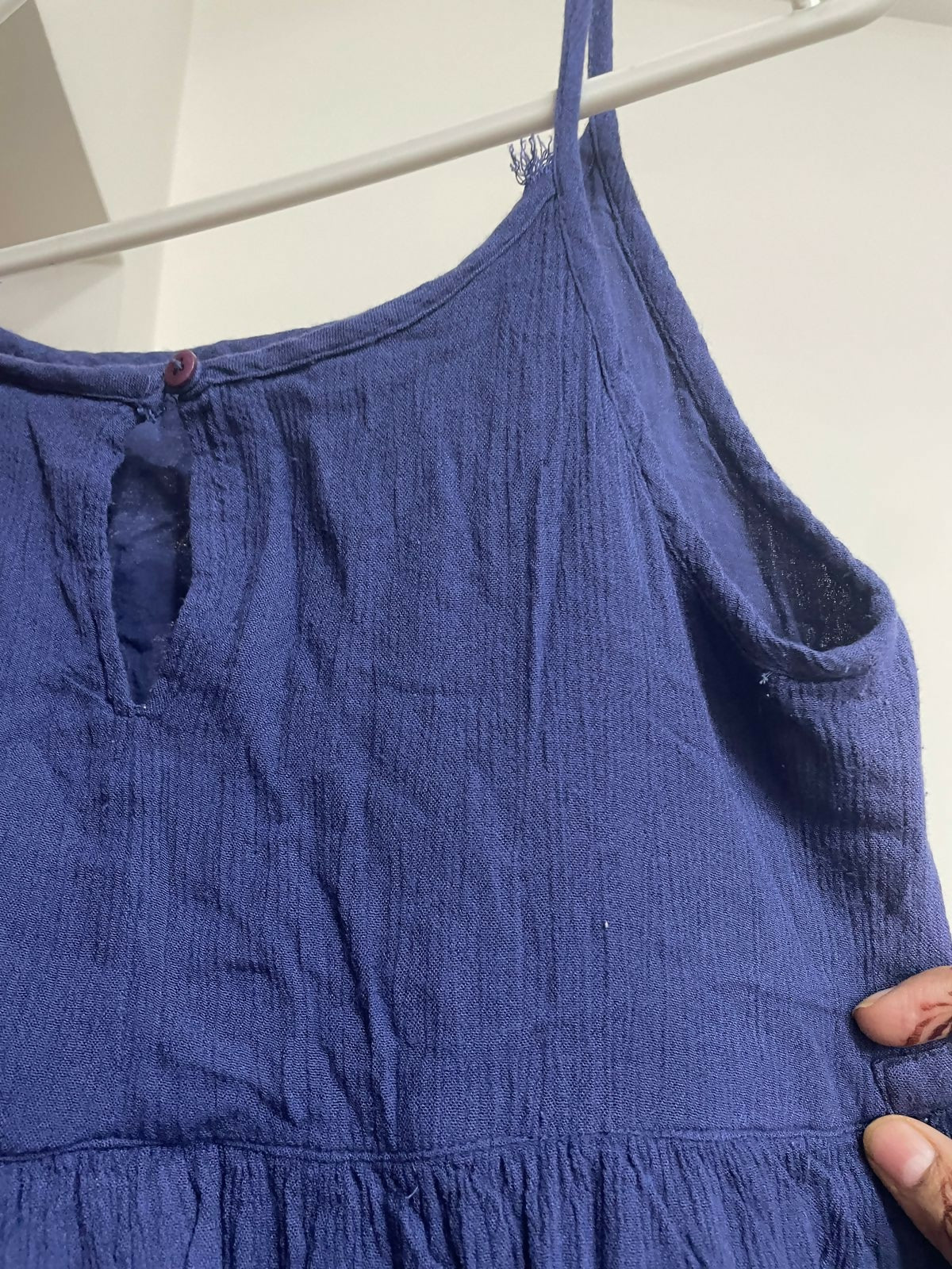 Blue dress on a hanger against a white background