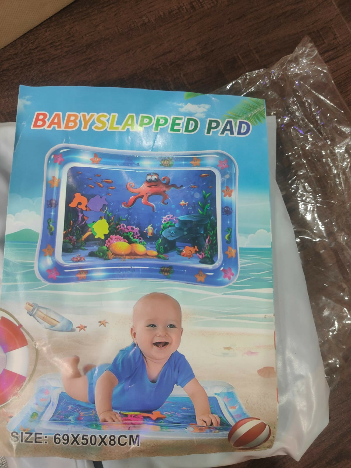 Baby slatted pad packaging with a child in a pool illustration