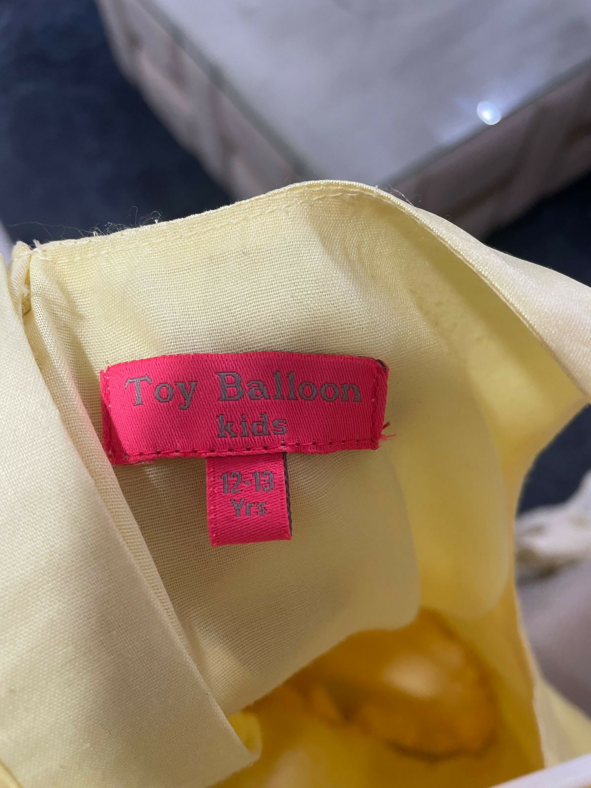 Close-up of a pink label on a yellow garment with a blurred background