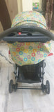 Stroller with a colorful canopy on a marble floor.