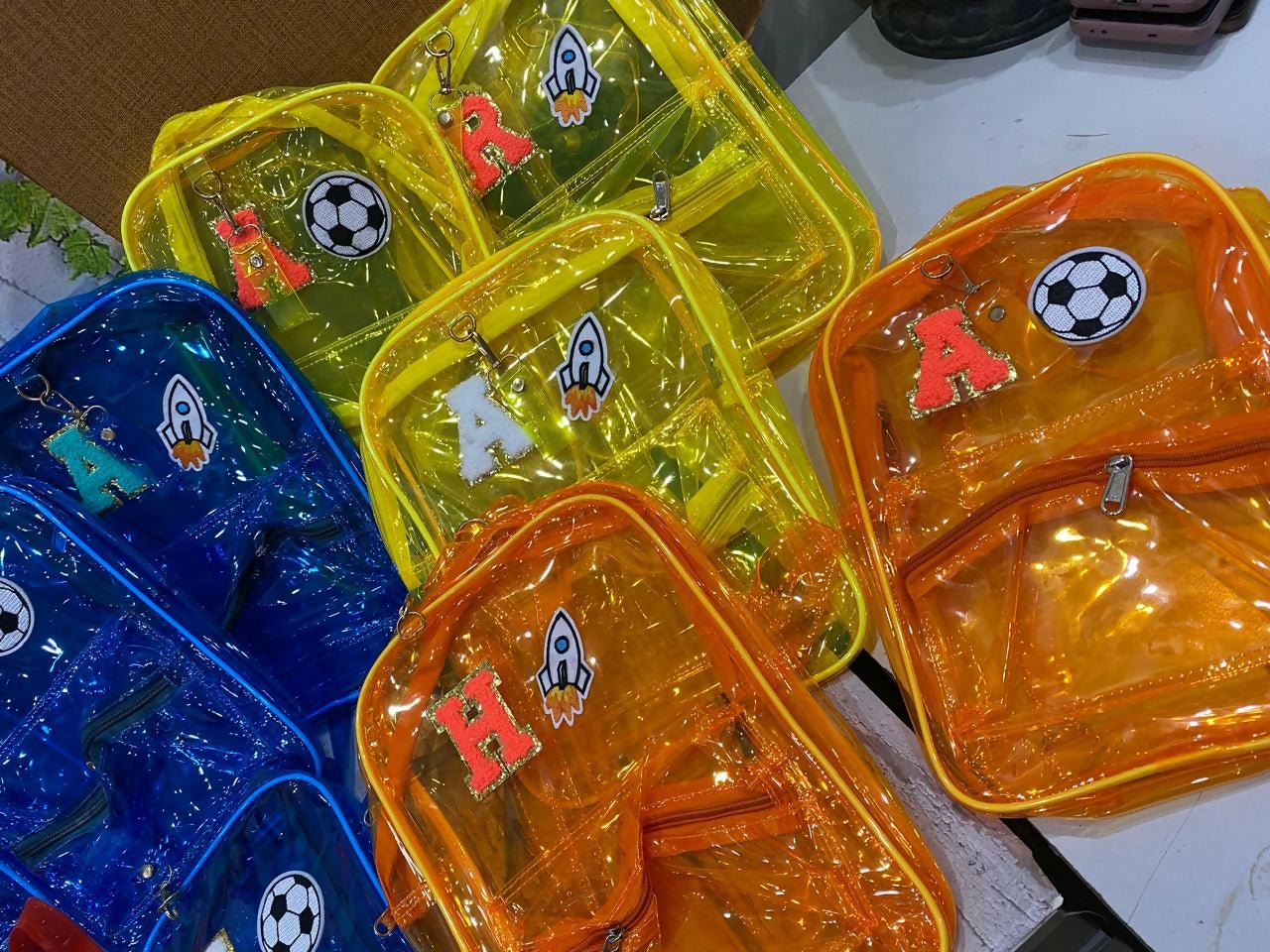 Colorful transparent bags with letter and symbol decorations on a white surface