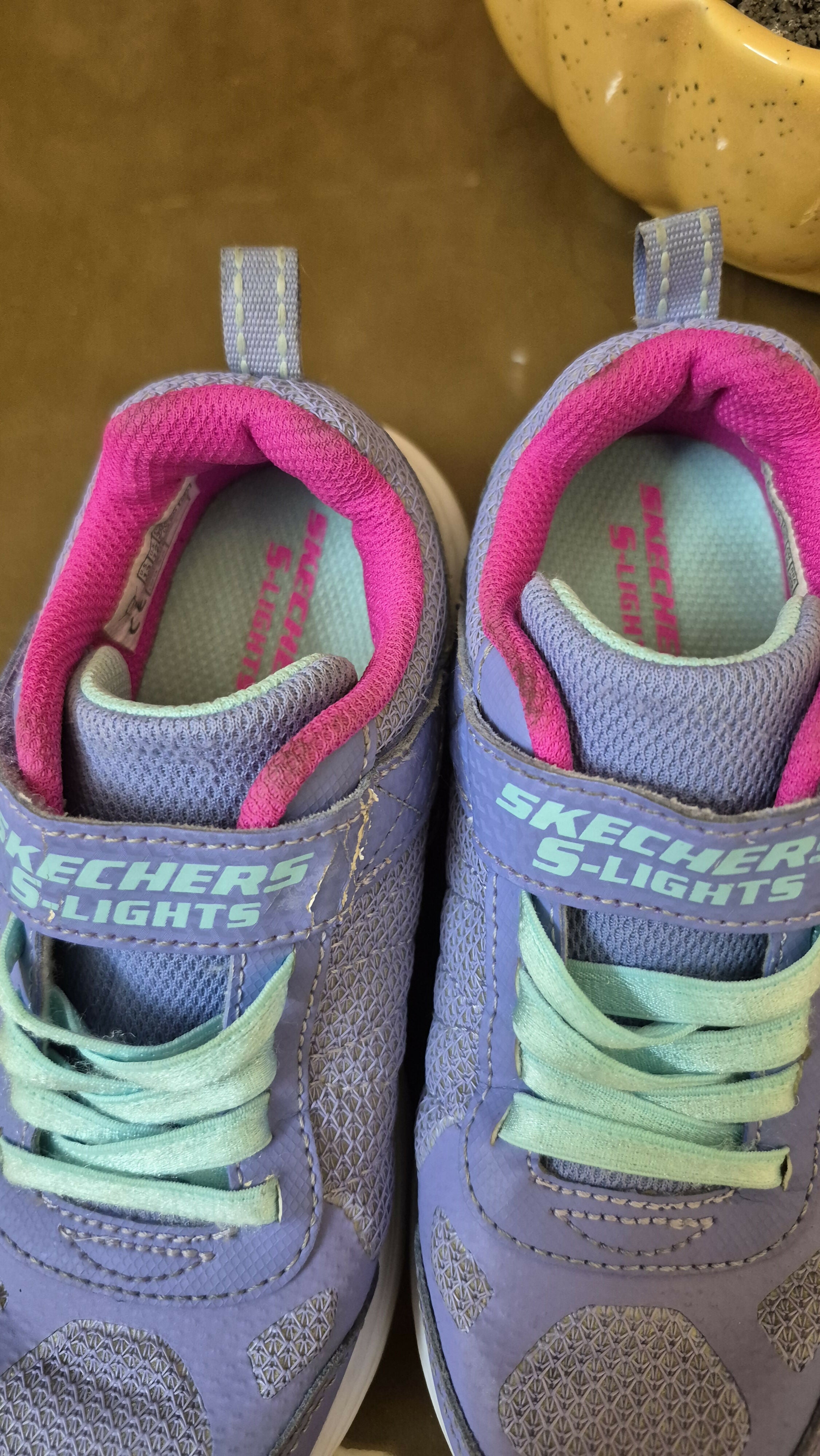 Purple and pink Skechers shoes with green laces