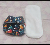 Colorful diaper with space design and white diaper cover on a light pink surface