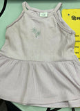 Light gray sleeveless top with embroidery on a green surface