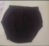 Black knitted headband on a light pink surface