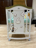 Children's crib with cartoon designs on a wooden floor