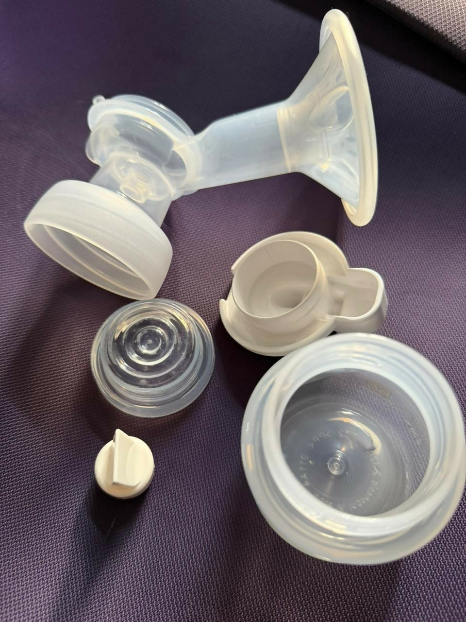 Silicone components of a breast pump on a purple surface
