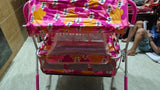 Child's toy cart with colorful fabric cover on a tiled floor.