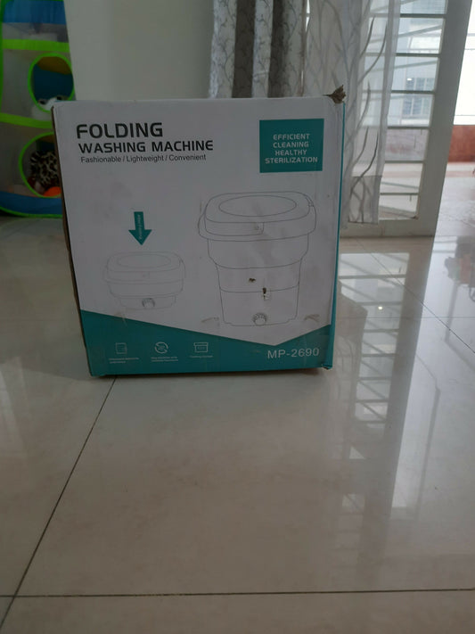 Box of a folding washing machine on a tiled floor