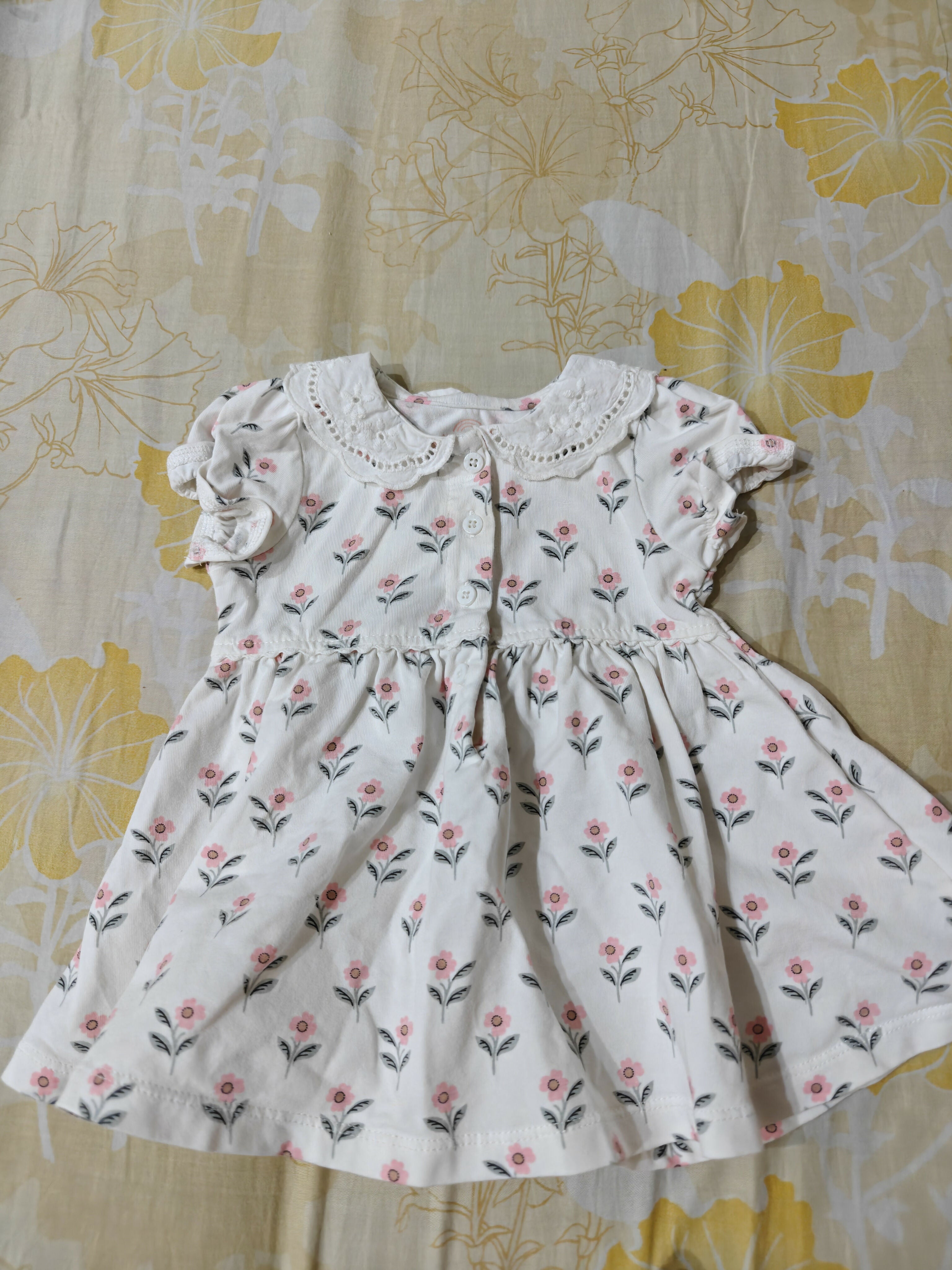 White dress with floral pattern on a floral fabric background