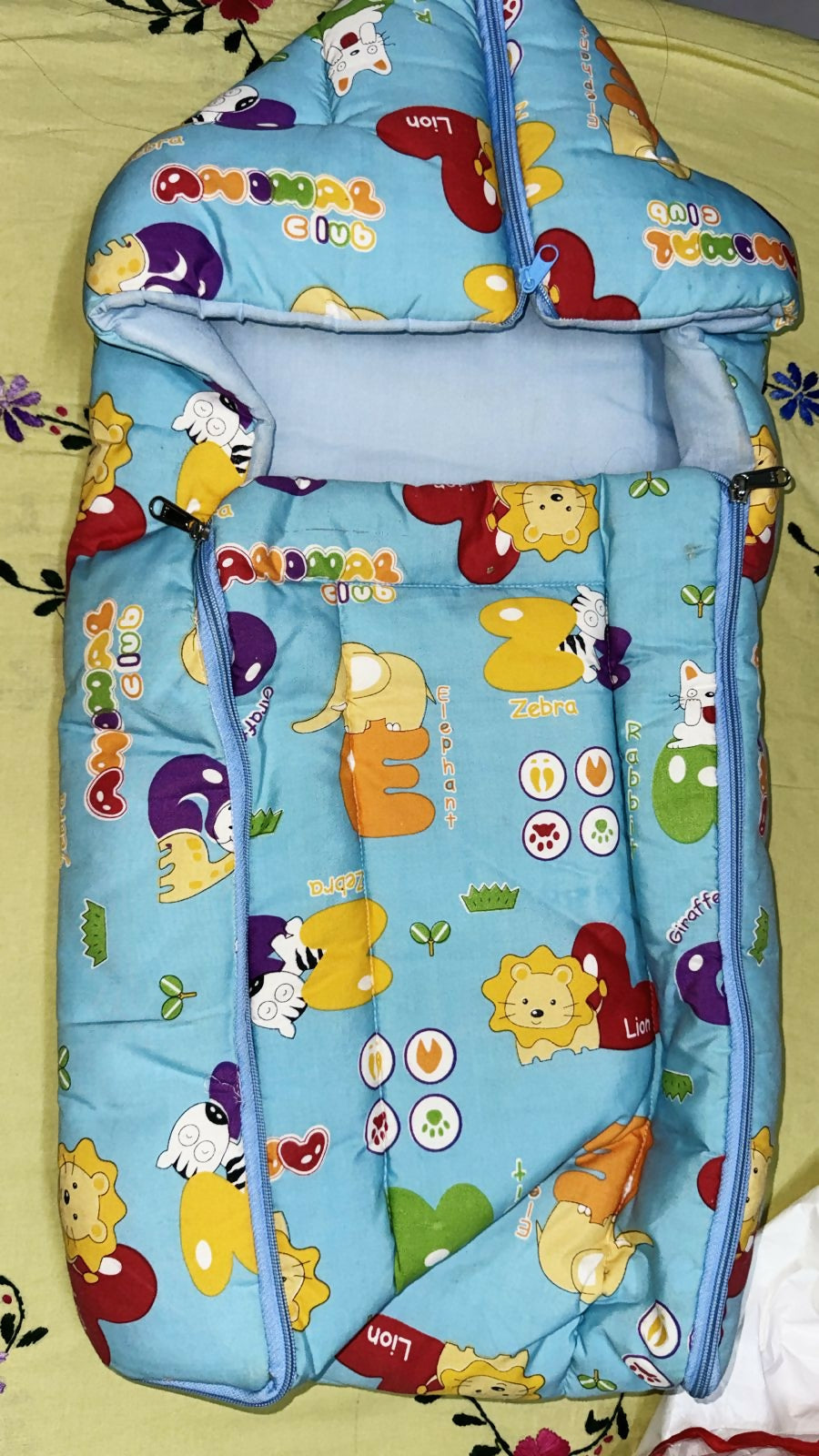 Children's sleeping bag with animal prints on a light green background