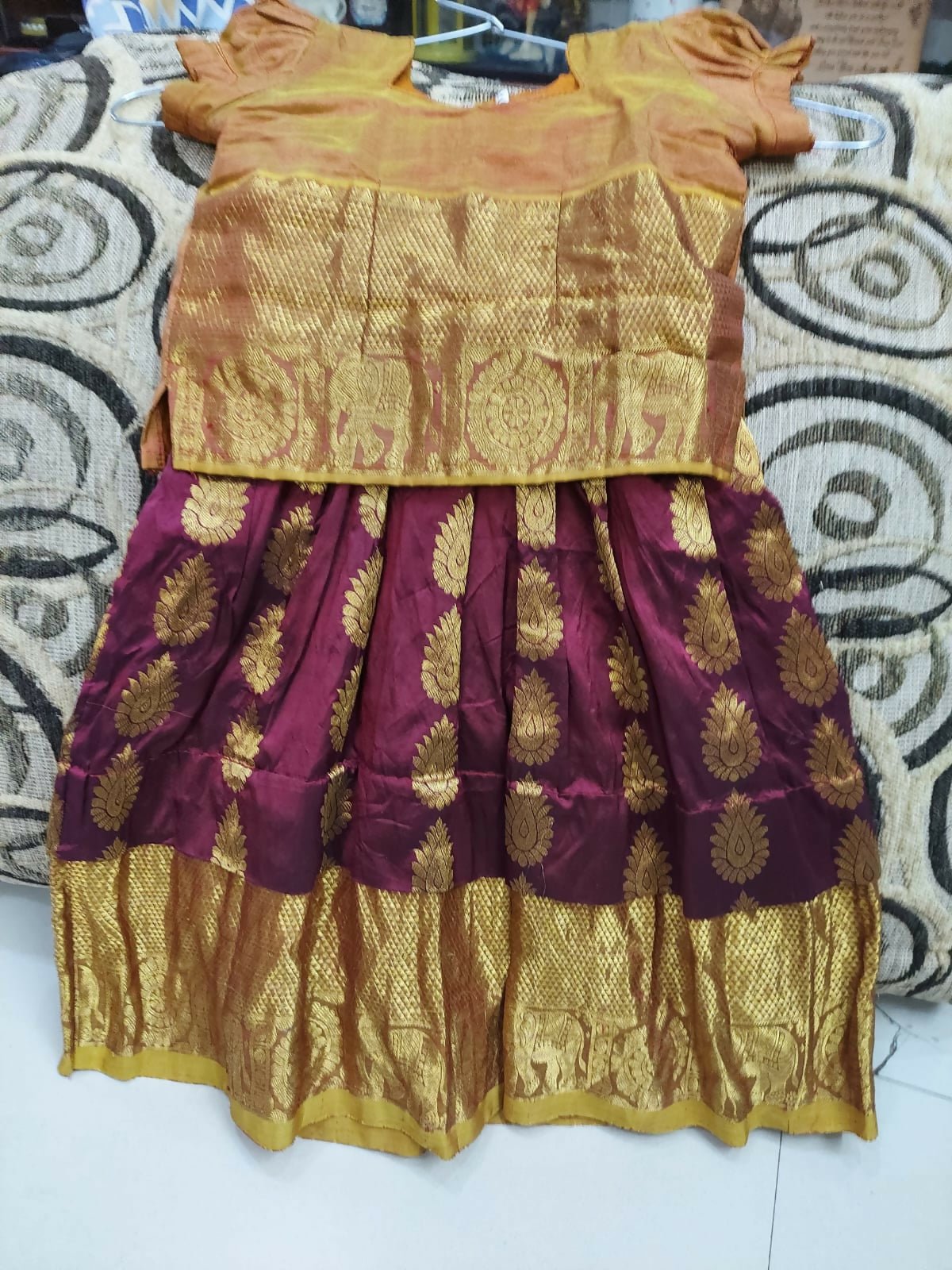 Traditional outfit with a gold blouse and maroon skirt