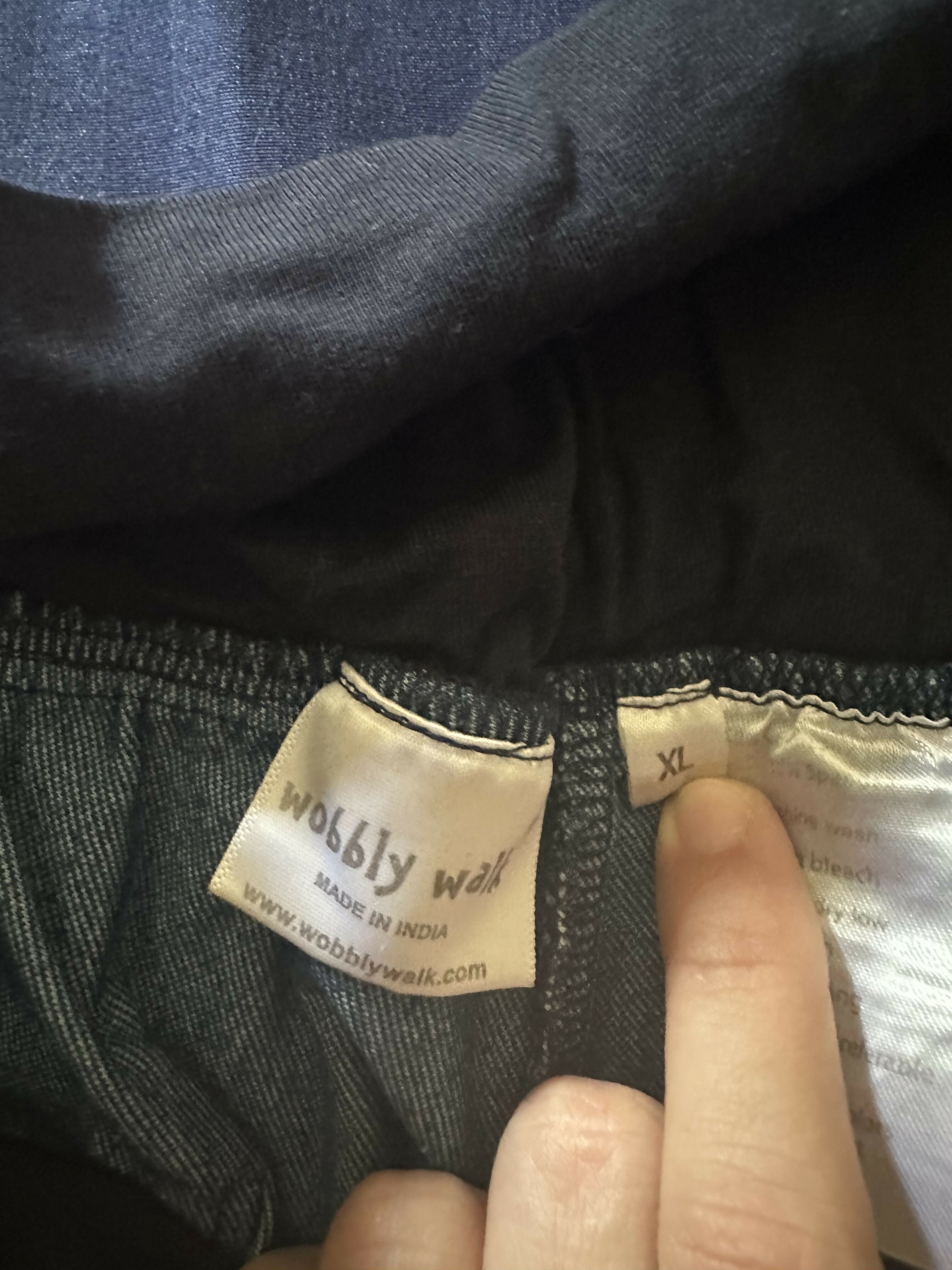 Close-up of a label on dark fabric with 'wobbly walk' branding.