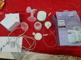 Philips Avent breast pump set on a red surface with packaging and manuals.