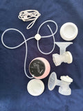 Breast pump parts including a digital display, tubing, and connectors on a blue surface.