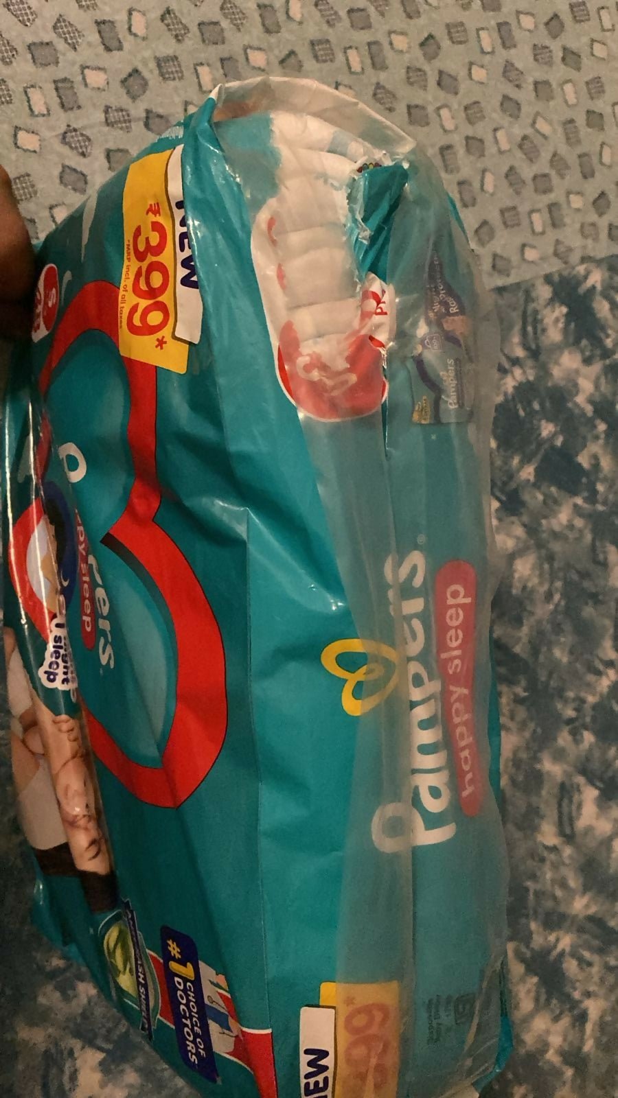 Pack of Pampers baby diapers with a price tag on a textured surface
