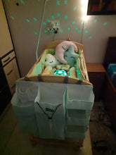 Baby crib with plush toys and a white cover in a room setting.