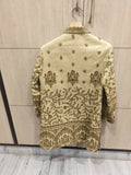 Embroidered traditional jacket on a hanger against a light wooden panel background