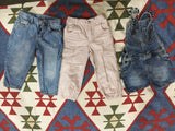 Three pairs of children's pants on a patterned rug