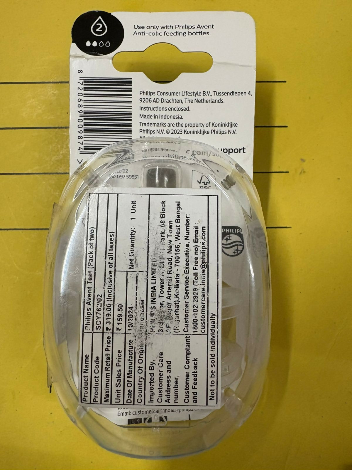 Clear plastic lid with Philips Avent label on a yellow background