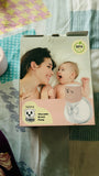 Product packaging for a wearable breast pump with a woman and baby illustration on a colorful background.