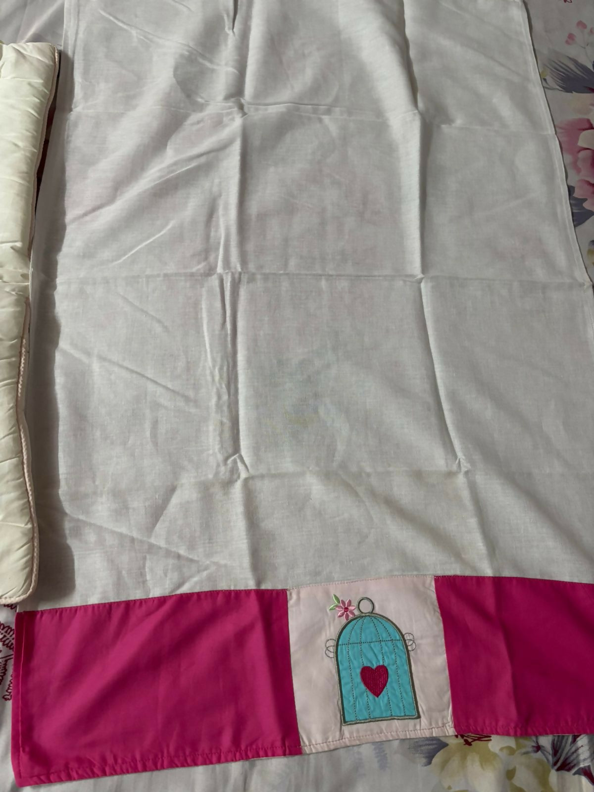 Blanket with a pink border and decorative elements on a floral background