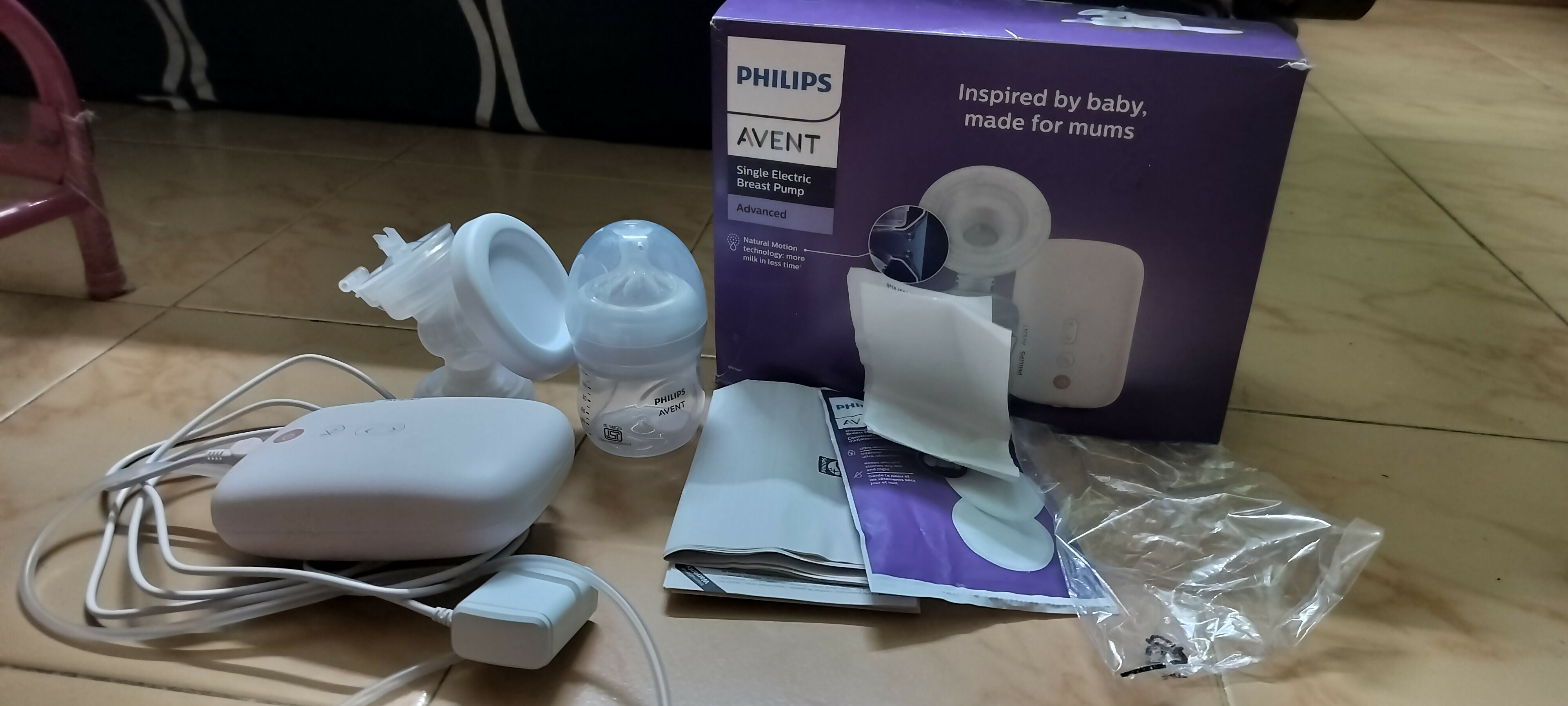 Philips Avent baby bottle and accessories on a wooden floor
