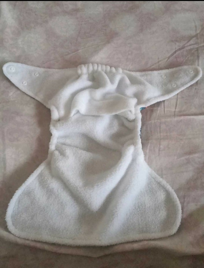 White cloth diaper on a pink textured surface