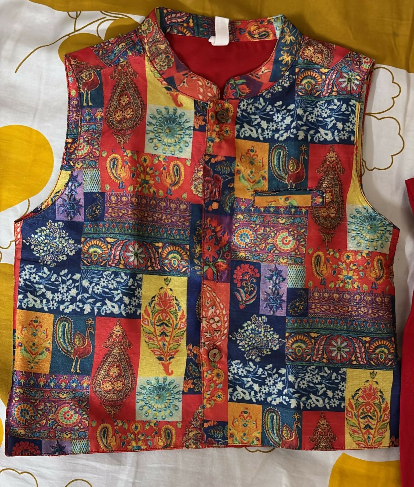 Colorful patchwork vest on a mannequin against a yellow and white background