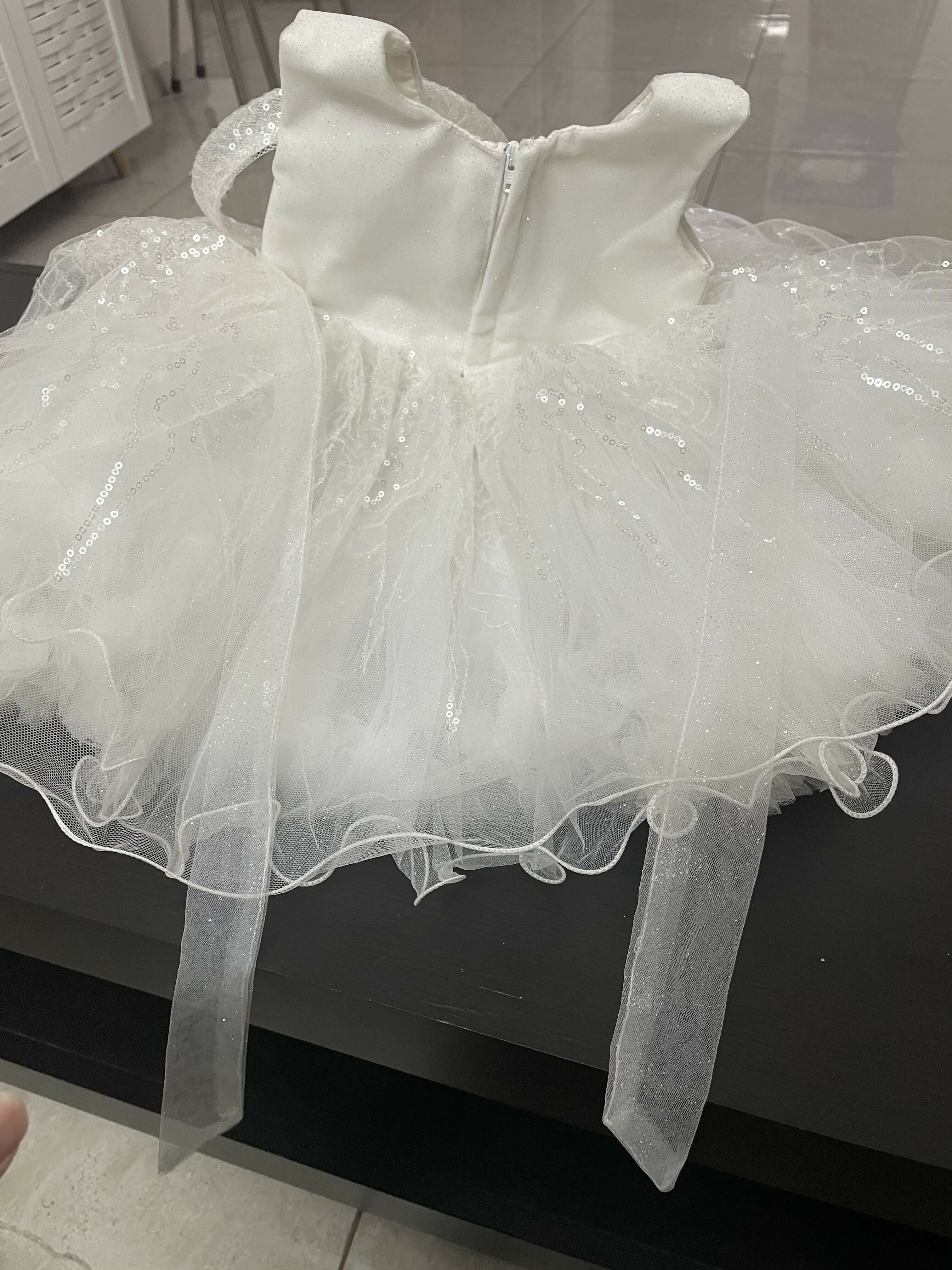 White dress with a sheer overlay on a black surface