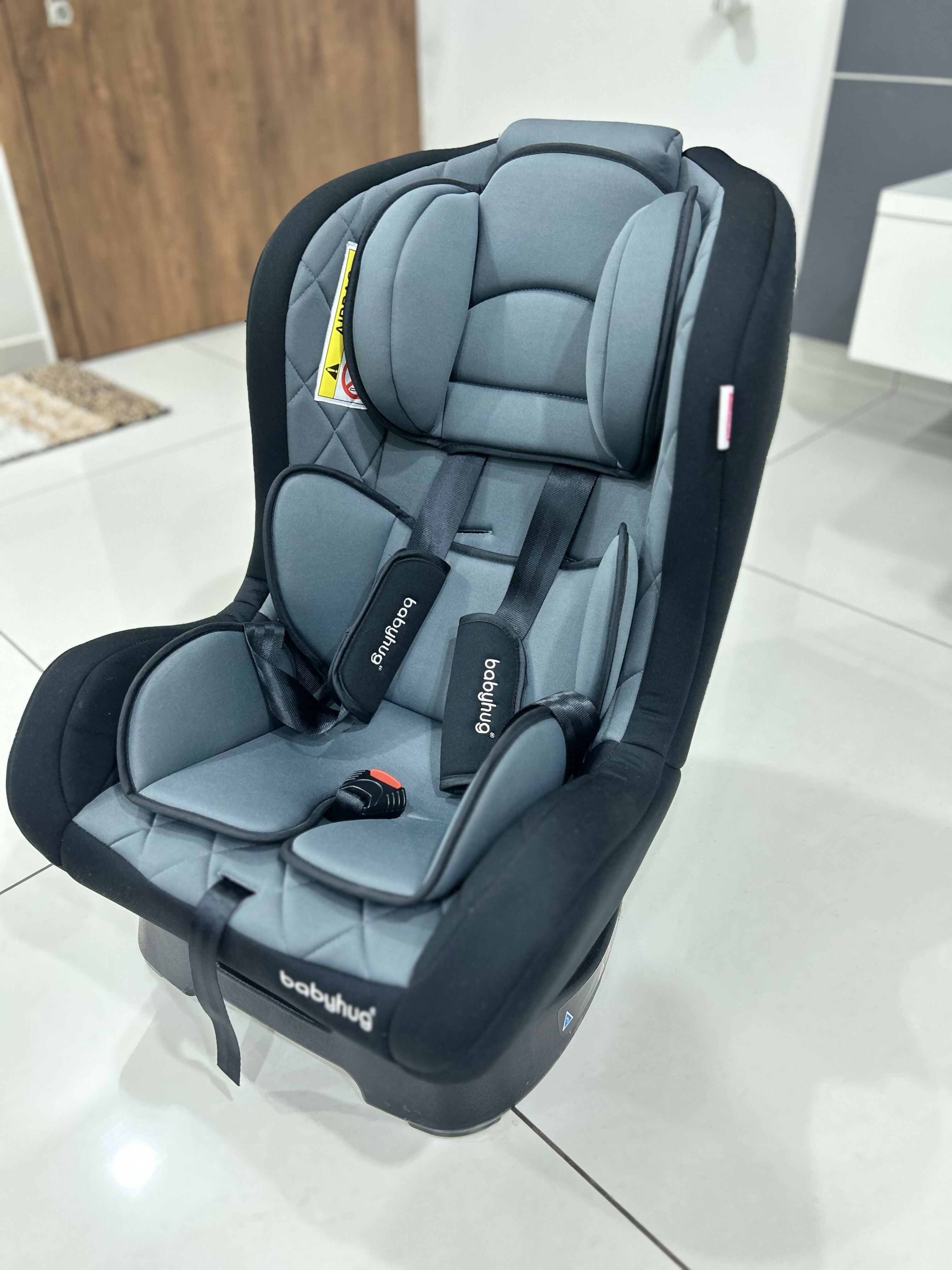 Gray and black car seat on a tiled floor
