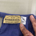 Roebuck & Co. label on a blue garment with a hand pointing to it.