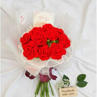 Bouquet of red artificial roses with a white ribbon on a white background