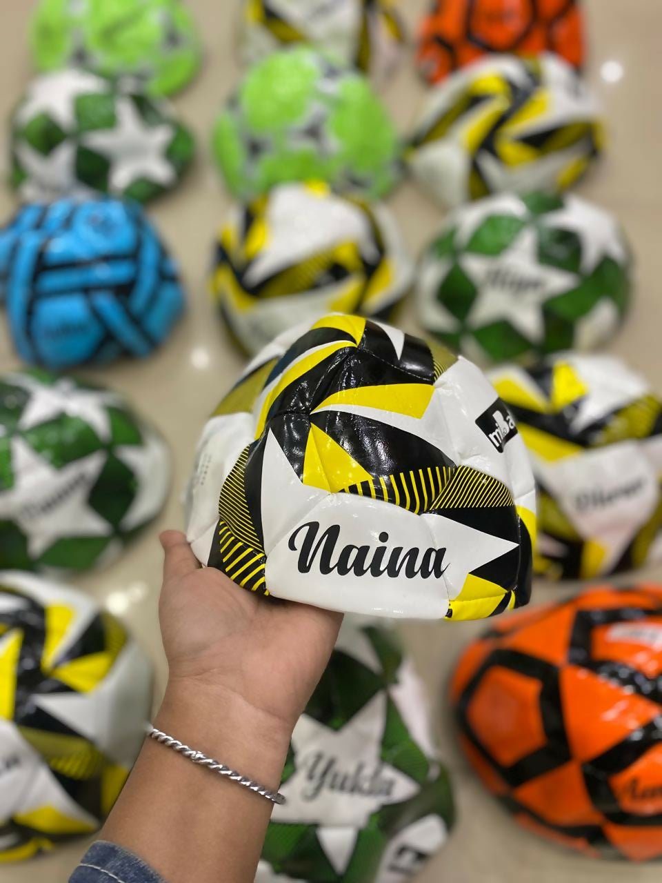 Customized size 5 football with child’s name printed, available in random colors with theme-based personalization options.