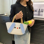 Person holding a white bag with blue bunny ears and a yellow tulip, standing in an indoor setting.