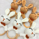 Set of crocheted bunny rattle toys on a soft surface