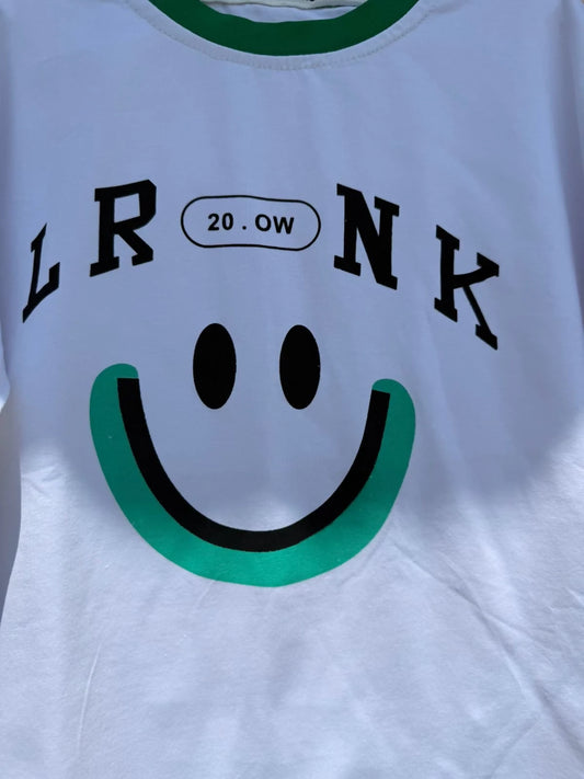 White t-shirt with black text and a green smiley face design 