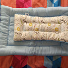 Baby crib bumper with patterned insert on a colorful quilt