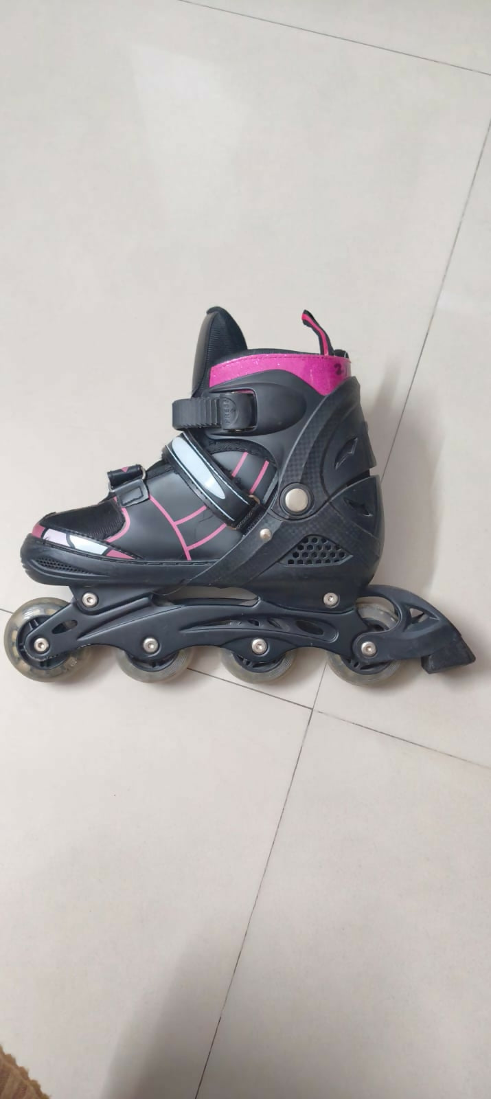 Black and pink roller skate on a light gray floor
