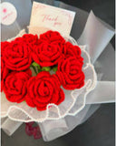 Bouquet of red roses with a 'Thank you' card on a gray surface