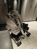 Beige stroller on a patterned floor next to a glass door