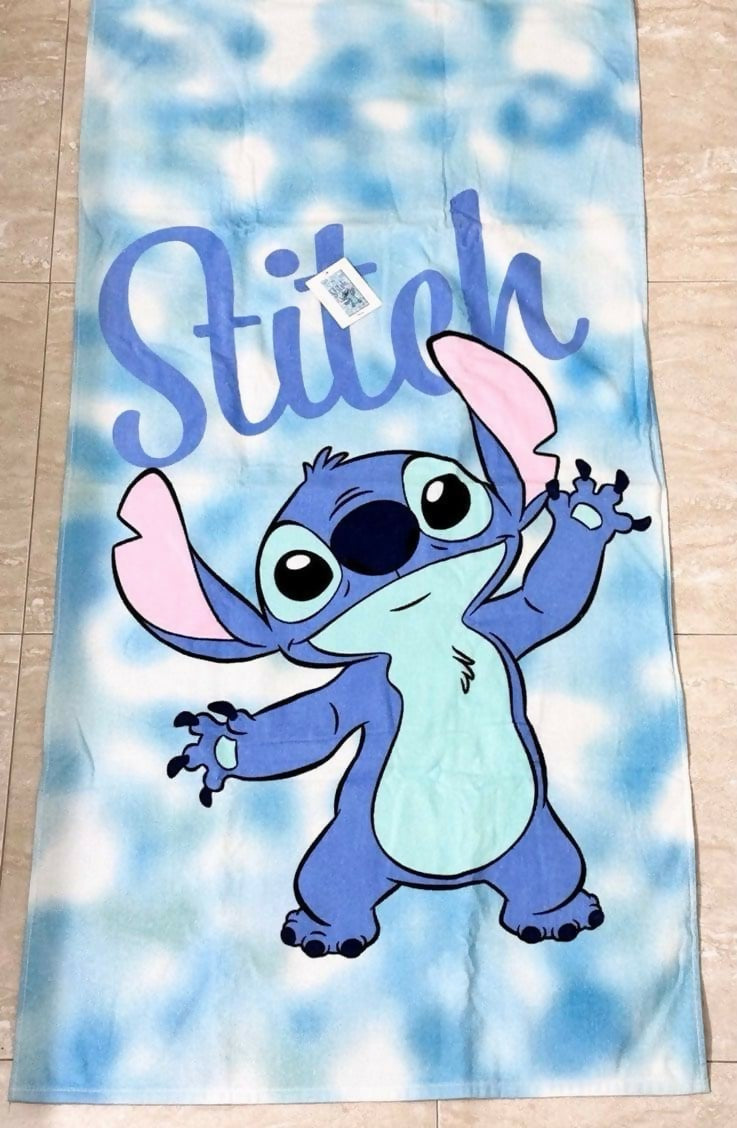 Towel with cartoon character 'Stitch' on a blue and white cloud pattern 