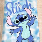 Towel with cartoon character 'Stitch' on a blue and white cloud pattern 