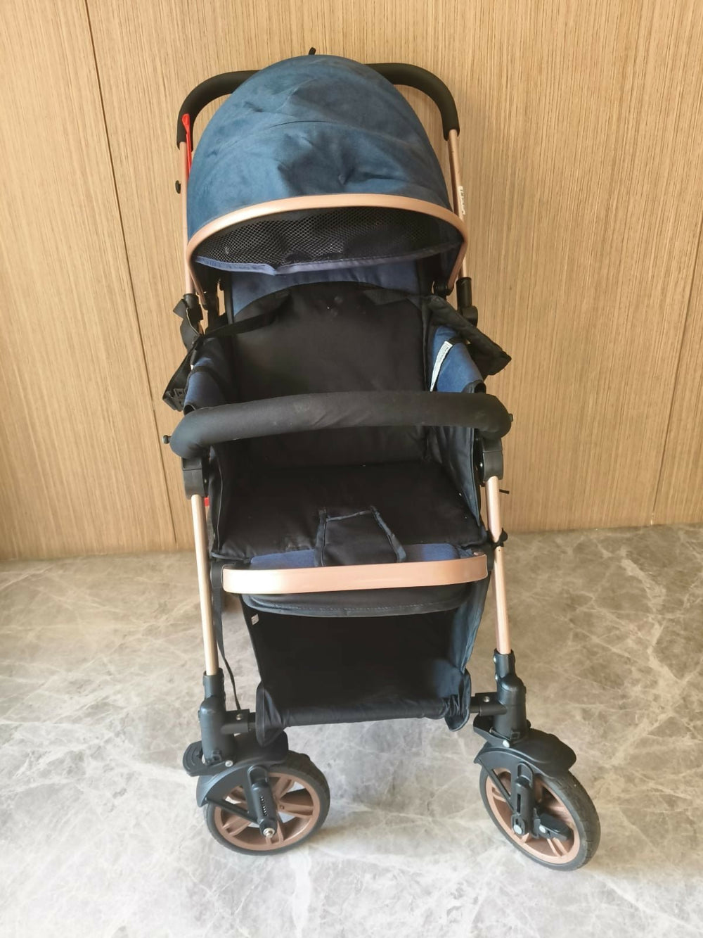 Blue and black stroller with rose gold accents 