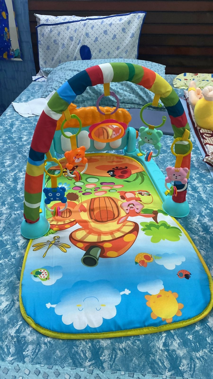 Colorful baby play mat with various toys on a blue surface