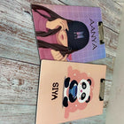 Two notebooks with different designs on a wooden surface
